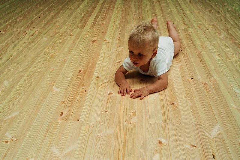 Dítě na borovicové podlaze